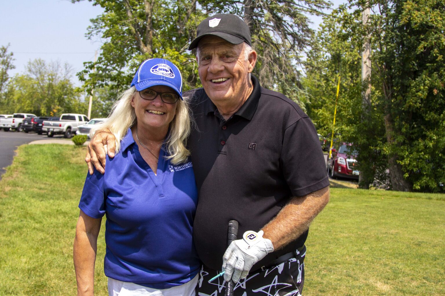 People in golf attire posing for a photo